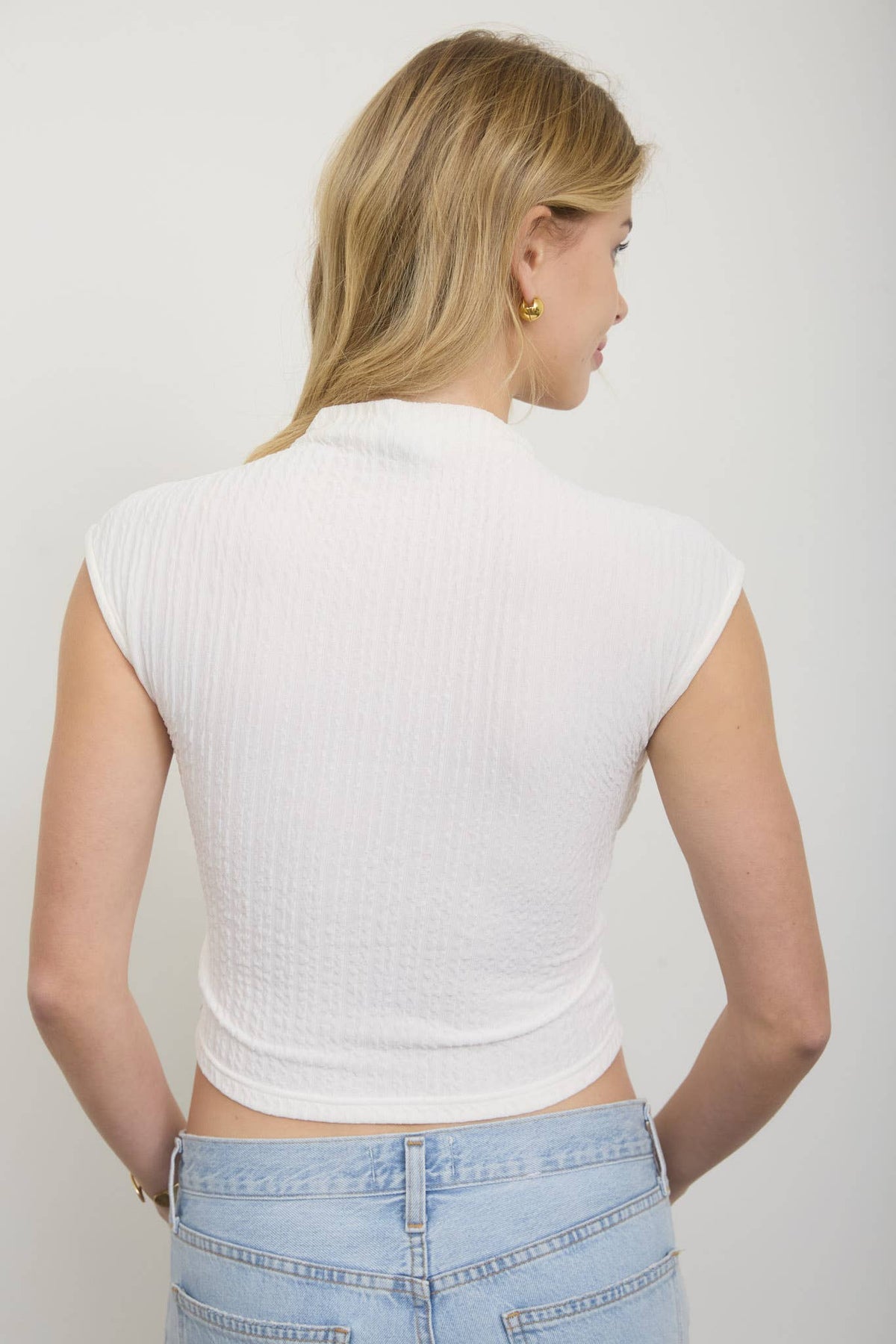 ASYMMETRICAL HEM MOCK NECK SLEEVELESS KNIT TOP